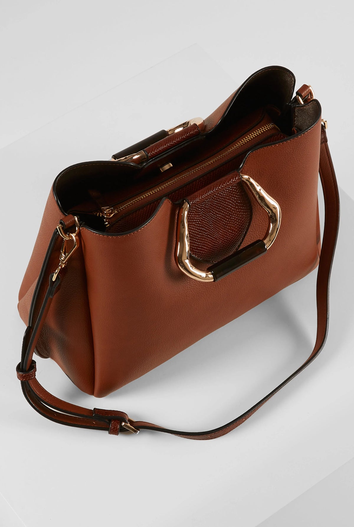 Brown handbag with top open and dark interior, featuring front metal clasp