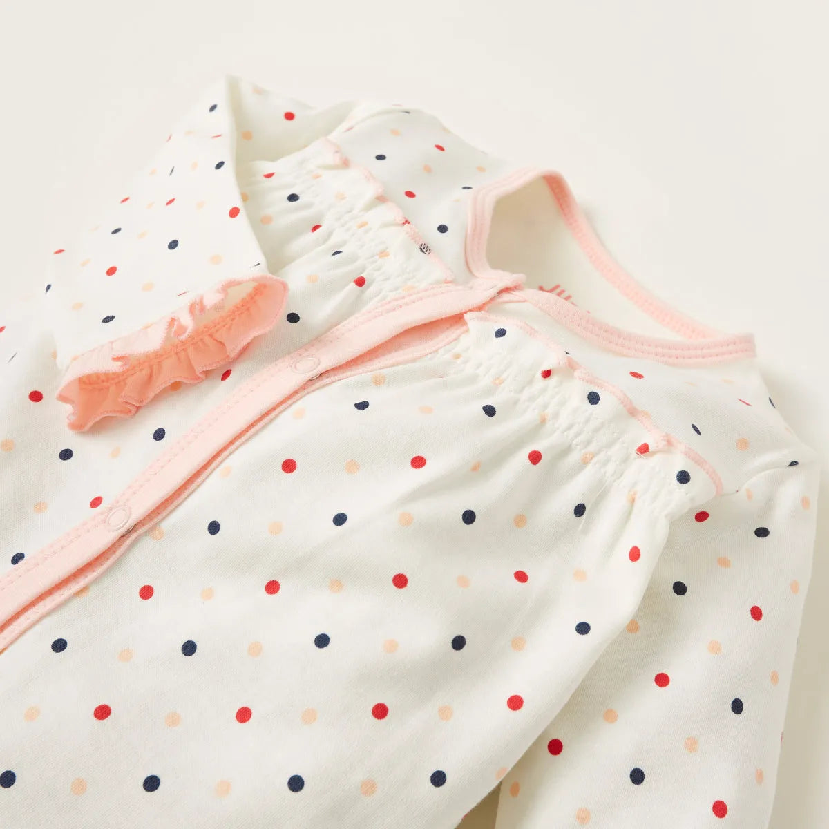Baby romper with multicolor dot pattern, pink trim neckline, long sleeves