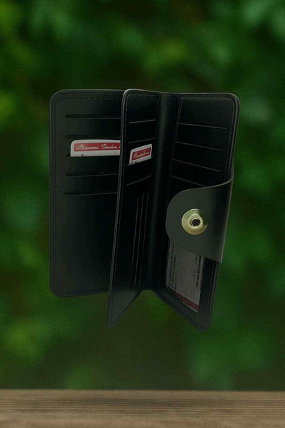 Dark leather bifold wallet open with ID window, card slots, and snap tab