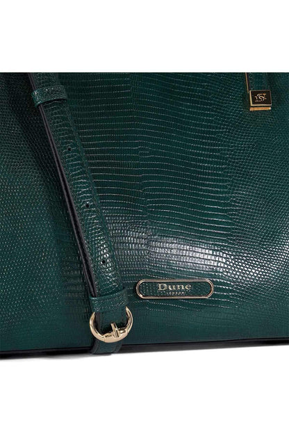 Dark green textured tote bag close-up with Dune London logo plaque and strap clip