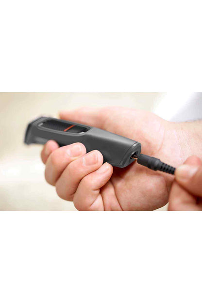 Handheld PHILIPS black trimmer with power cord connected and orange indicator