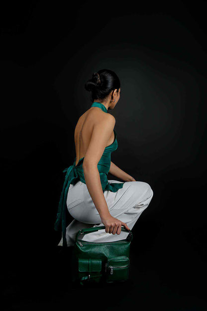 Emerald green handbag with top handle and front flap, side view