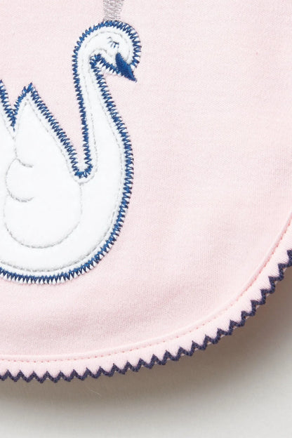 Baby bib closeup, pink with blue swan embroidery and scalloped stitched border