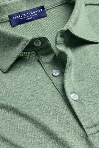 Green polo shirt fabric with button placket and logo neck label