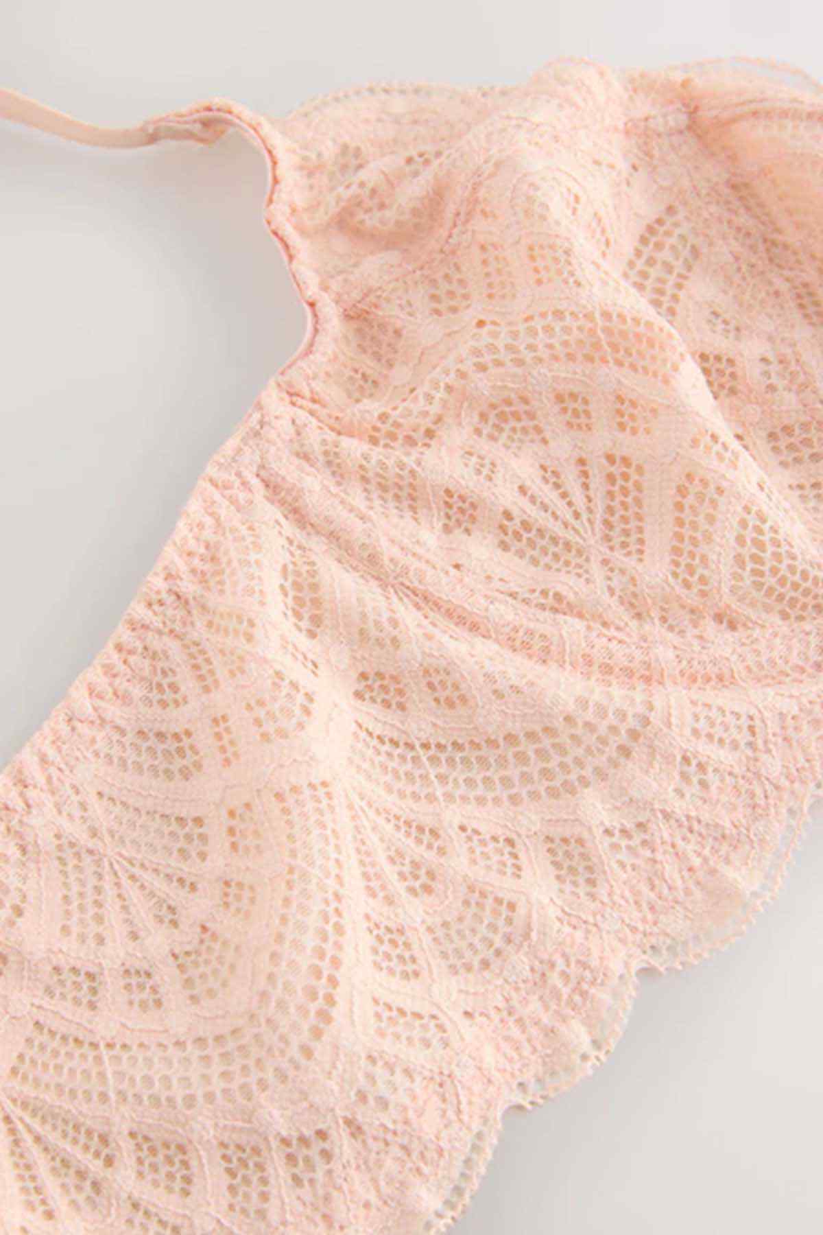 Coral pink lace fabric with floral scalloped pattern.