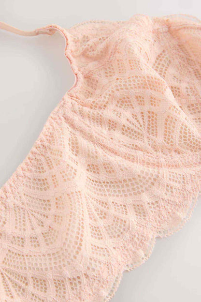Coral pink lace fabric with floral scalloped pattern.