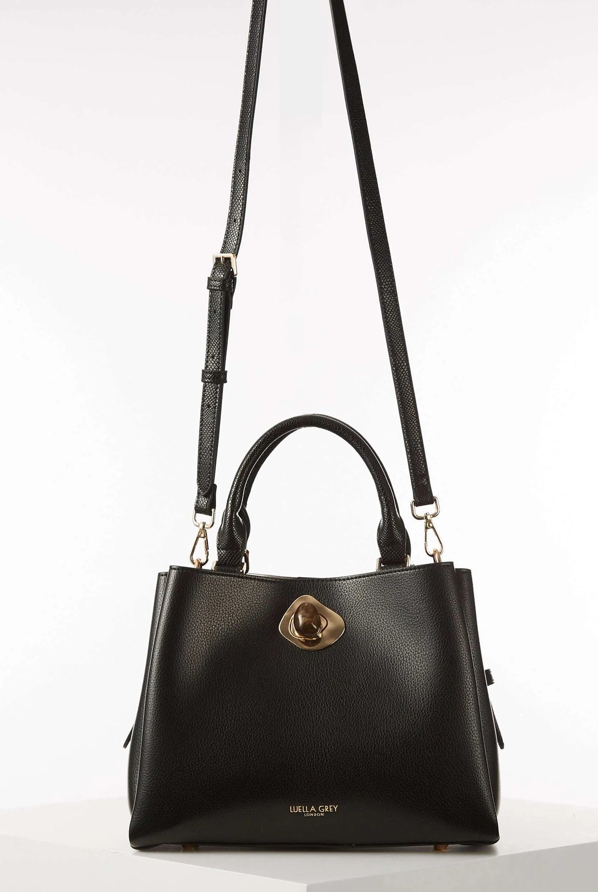 Black handbag with long shoulder straps, top handle, and gold clasp