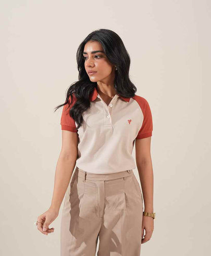 Fitted polo shirt with red sleeves, small chest logo; khaki pleated trousers