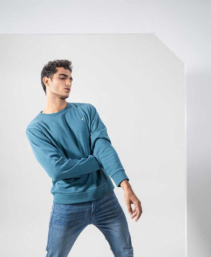 Fitted teal crewneck long-sleeve shirt with long sleeves and blue jeans