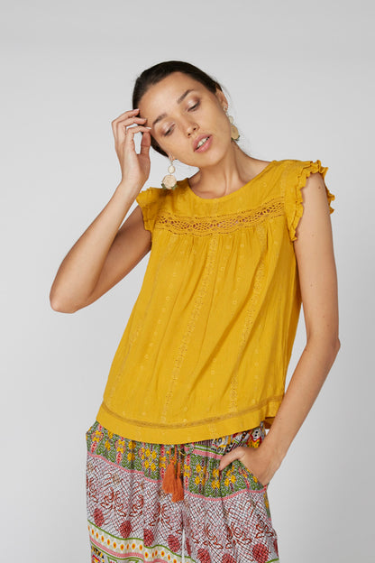 Yellow sleeveless blouse with ruffled shoulders and embroidered lace yoke