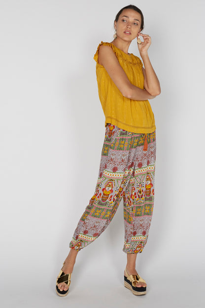 Yellow sleeveless blouse with patterned loose pants, ruffled shoulder details