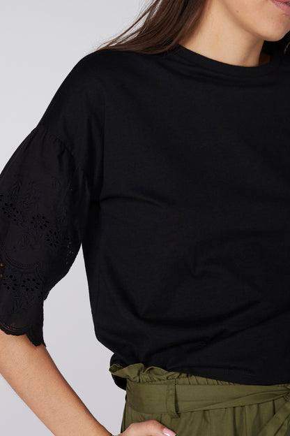 Black top with scalloped eyelet sleeves and olive waistband