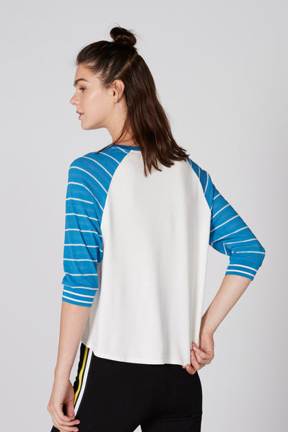 White raglan baseball tee with blue striped sleeves and Soundstate graphic, side view