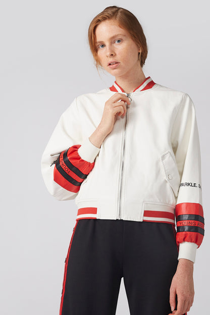 White zip-up jacket with red striped cuffs and collar, side pockets, embroidered patch.