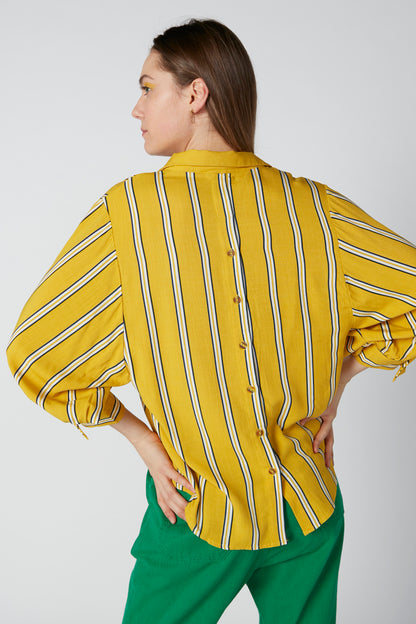 Splash striped blouse back view with elastic waist; green pants and long sleeves