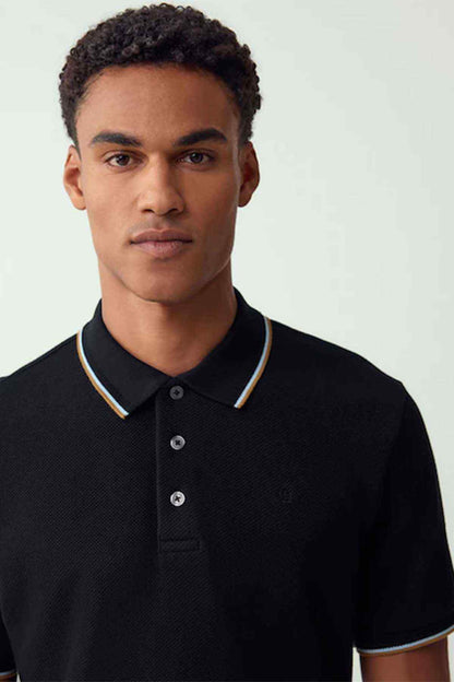 Black polo shirt with contrast collar trim and button placket, close-up