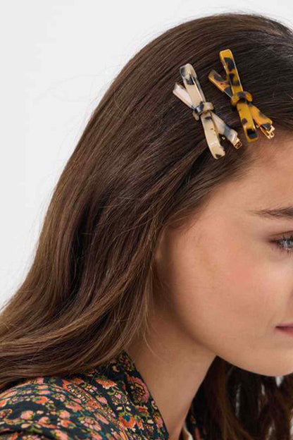 Tortoiseshell hair clips with bow design, set on dark brown hair