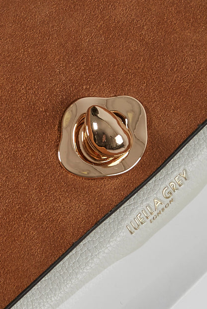Brown leather wallet close-up: gold snap hardware and embossed 'LUELLA GREY'