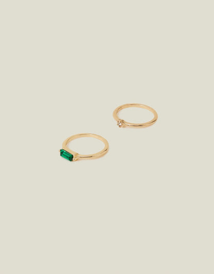 Two gold-tone stack rings: green baguette gemstone and crystal detail band