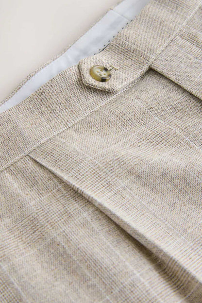Light beige trouser waistband close-up with round button and facing