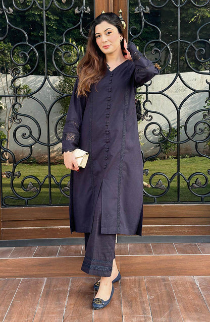 Black long button-front tunic with lace cuffs and matching pants, hand-up side view