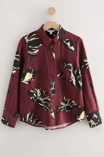 Wine floral long-sleeve button-up shirt on a wooden hanger