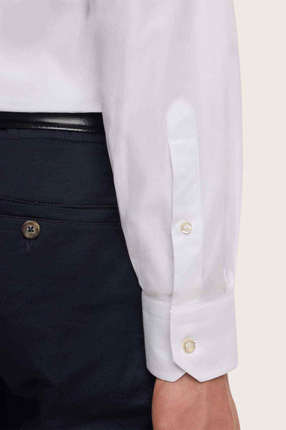 White dress shirt sleeve cuff with gold-tone button and placket
