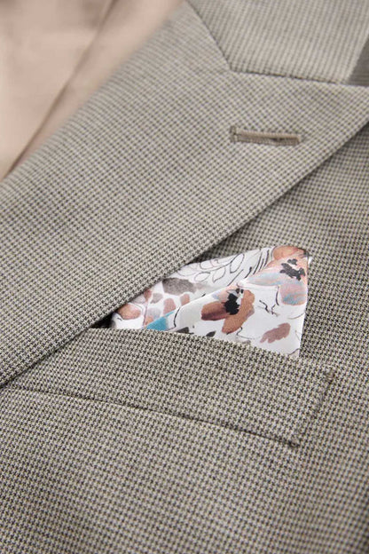 Men's gray blazer chest area with flap pocket and floral pocket label, close-up.