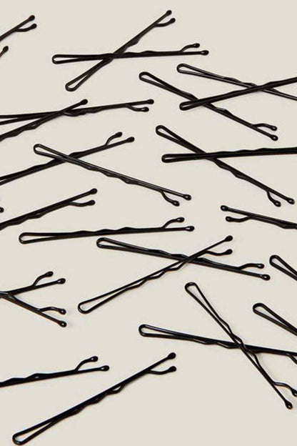 Black hair grip pins, scattered close-up
