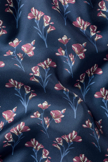 Blue fabric close-up with pink and plum floral sprig pattern