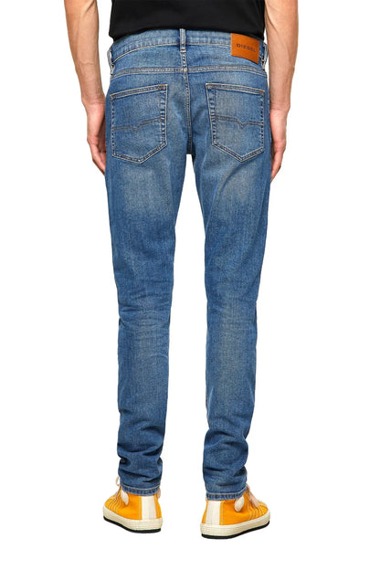 Light blue denim jeans with front pockets and orange logo patch at waistband