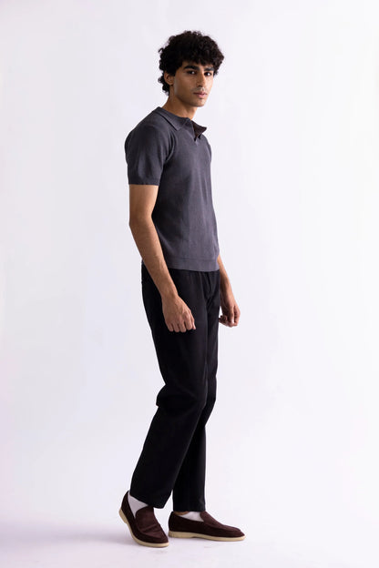Men's dark gray polo shirt, short sleeves and collar, side view with black pants