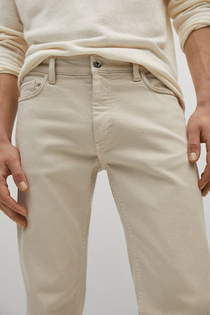 Beige denim jeans front detail: zip fly, belt loops, and stitched pockets