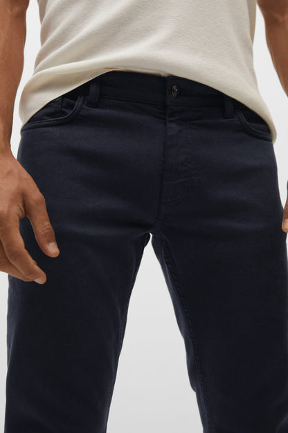 Dark navy jeans close-up: zip fly, button waistband, front pockets