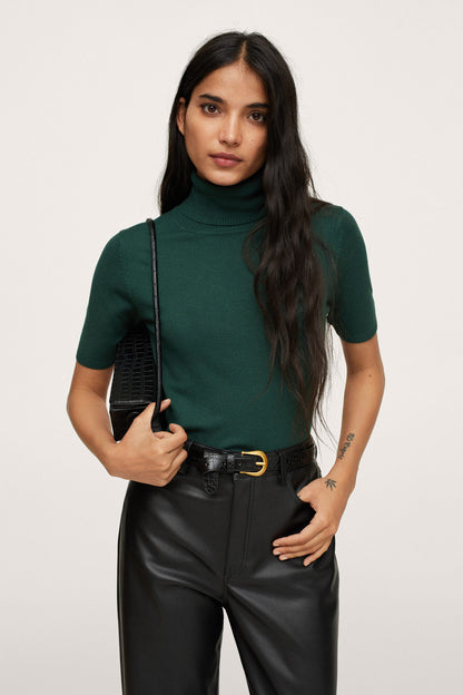 Emerald green short-sleeve turtleneck knit top with black leather-look trousers