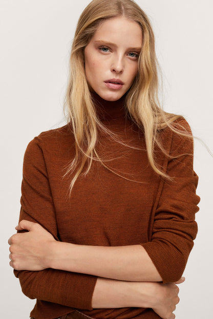 Russet knit turtleneck sweater with long sleeves, front view with crossed arms