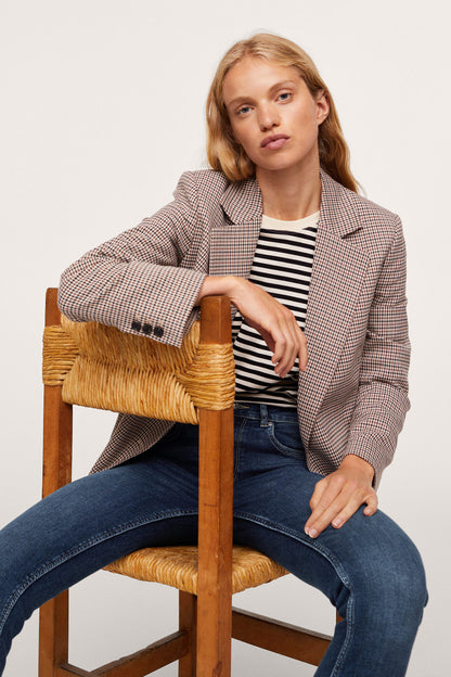 Dark blue skinny jeans with front pockets and slim fit, worn while seated