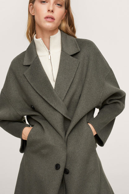 Dark green double-breasted coat close-up with notched collar and black buttons