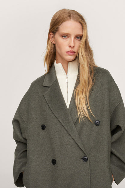 Dark green double-breasted long coat front view with notched lapels and buttons