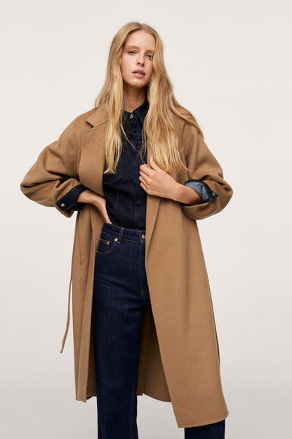 Tan long belted coat with notch lapels and dark buttoned cuffs