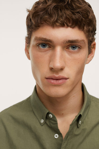 Men's khaki button-up shirt close-up of collar and button placket