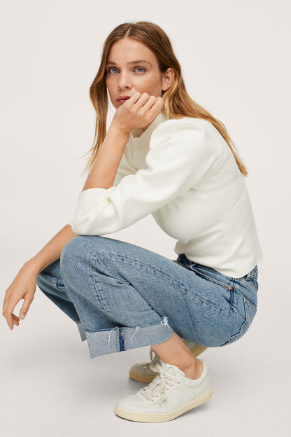 Ecru long-sleeve mock-neck top with draped shoulder and puffed sleeve cuffs