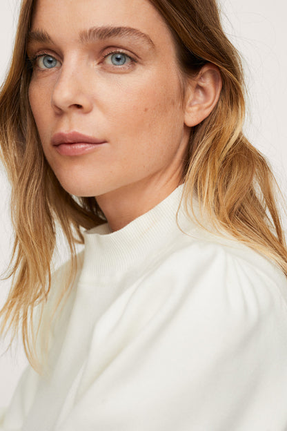 Ecru mock-neck knit top with ribbed high collar and soft texture