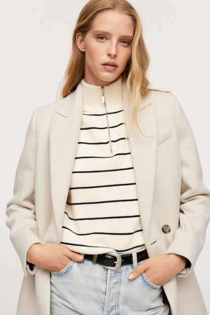 Light grey blazer worn open with long sleeves and double-button cuffs