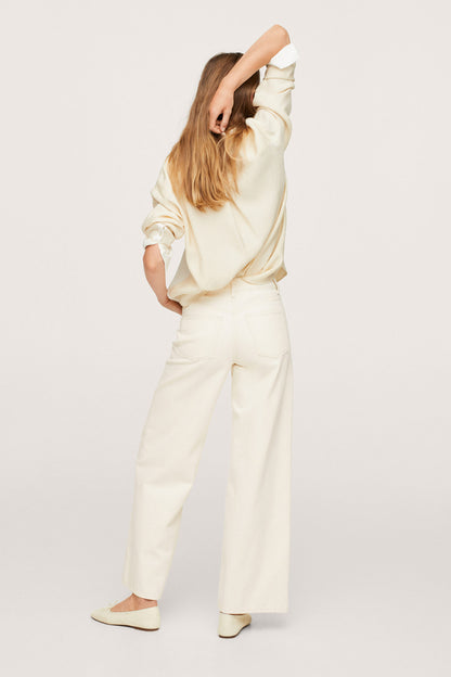 Ecru button-up shirt and wide-leg trousers set, angled pose with one arm raised