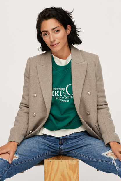 Women's taupe blazer, gold buttons, flap pockets, worn over green top