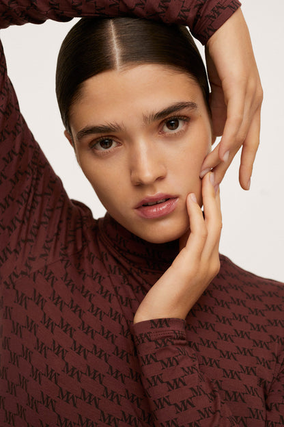 Burgundy patterned high-neck top close-up with long sleeves at wrist