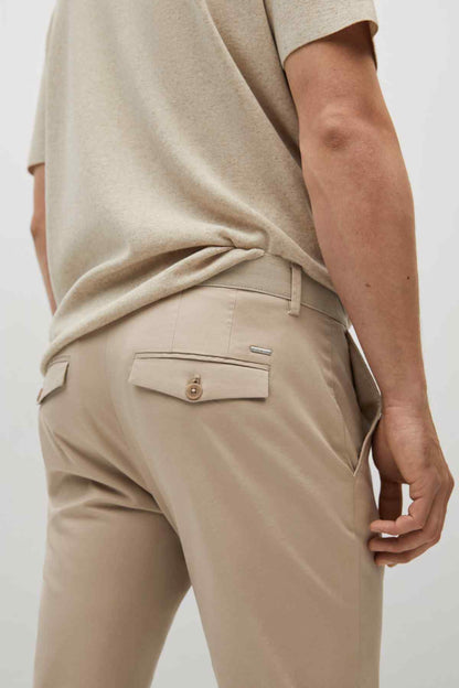Beige chino pocket detail with flap and metal button, plus belt loops