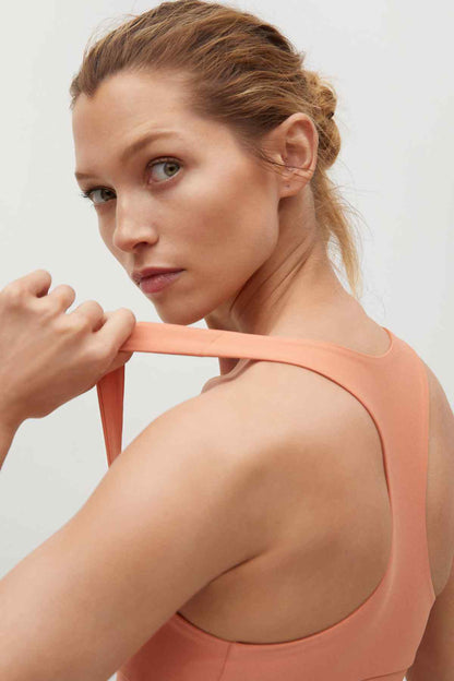 Peach sports bra back view with racerback straps and scoop neckline