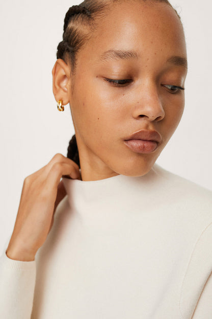 Ecru crew-neck sweatshirt neckline and smooth knit texture